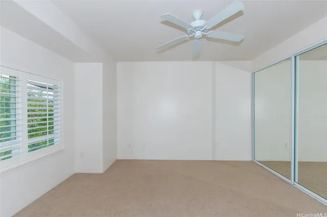 an empty room with a window and a fan