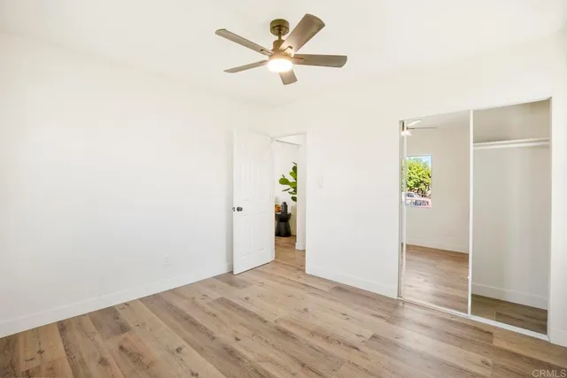 a view of an empty room and window with wooden floor