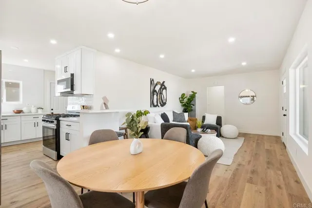 a large kitchen with sink a refrigerator and dining table
