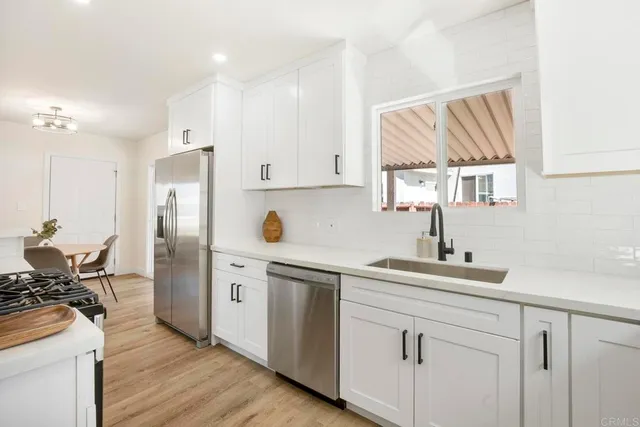 a kitchen with a sink cabinets stainless steel appliances and a window
