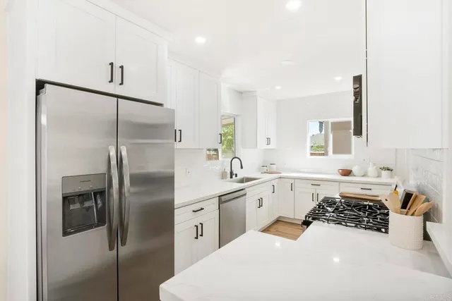 a kitchen with a sink a refrigerator and cabinets
