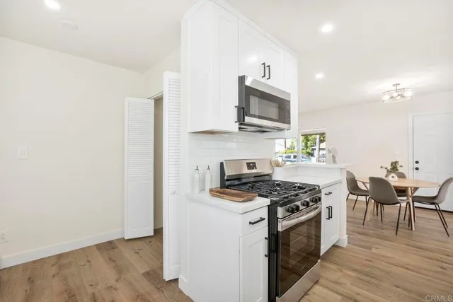 a kitchen with stainless steel appliances a stove a sink and a microwave