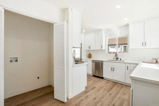 a kitchen with a sink cabinets stainless steel appliances and a window
