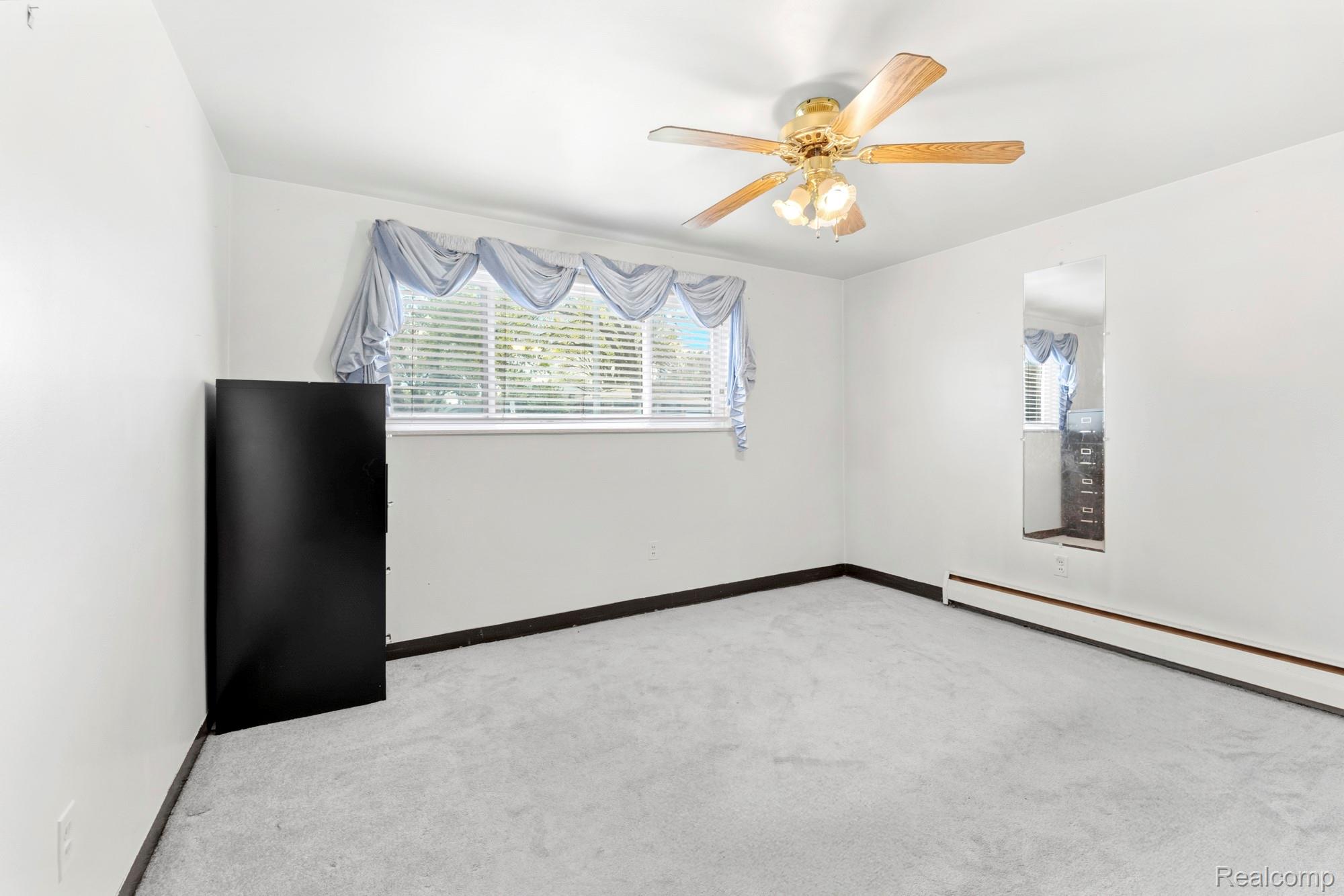 23410 Joy Road Redford, MI 48239 - Photo 12 of 25 Spare room with light carpet, a ceiling fan, and baseboard heating