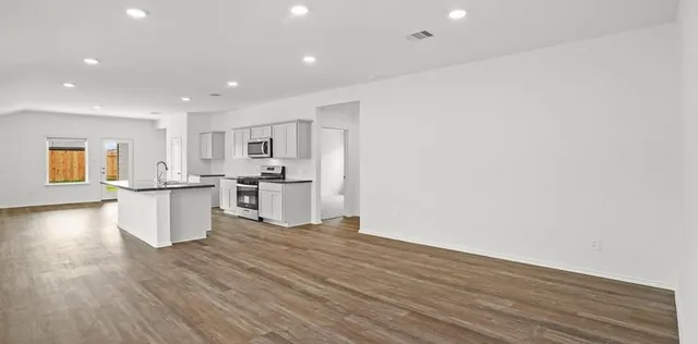 a view of kitchen with wooden floor and electronic appliances