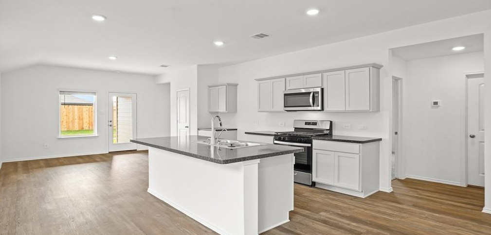 23907 Stardust Valley Dr Spring Spring, TX 77373 - Photo 7 of 9 a kitchen with stainless steel appliances granite countertop a sink stove and refrigerator
