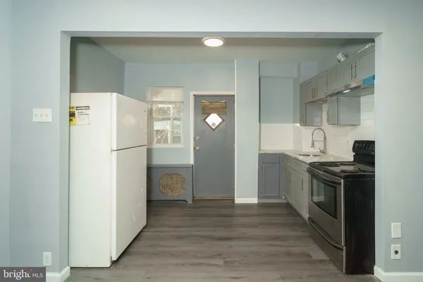 a kitchen with a refrigerator a stove and cabinets