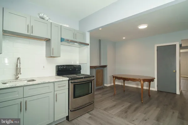 a kitchen with stainless steel appliances a stove a sink and a refrigerator