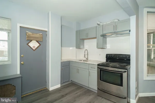 a kitchen with stainless steel appliances white cabinets and stove top oven