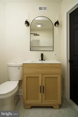 a bathroom with a sink a toilet and mirror