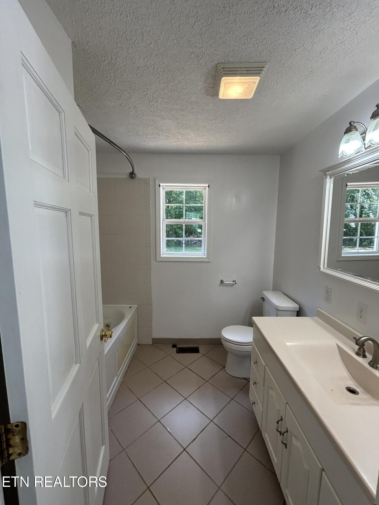 2702 Baseline Road Jamestown, TN 38556 - Photo 17 of 22 a bathroom with a double vanity sink a toilet and a window
