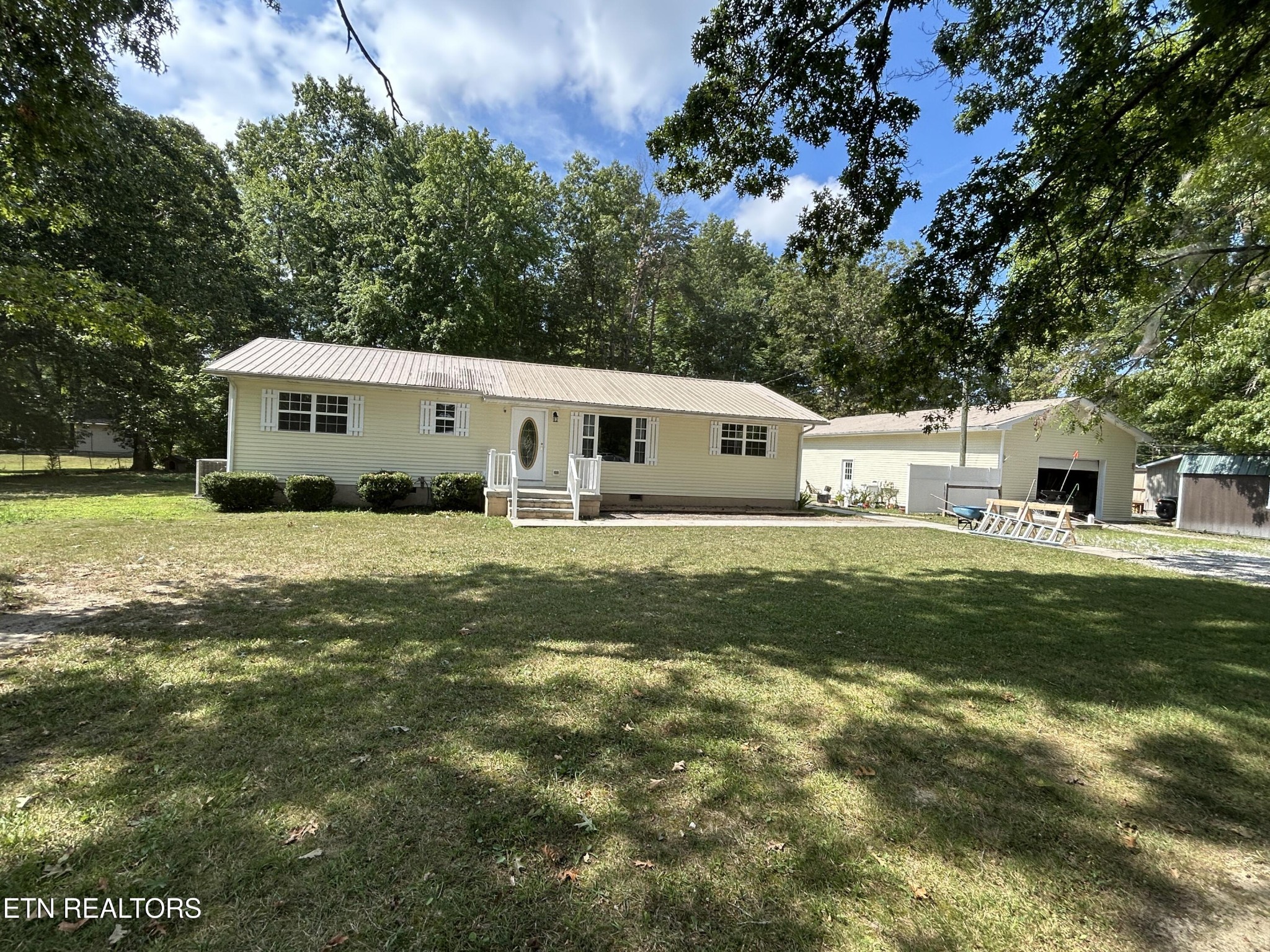 2702 Baseline Road Jamestown, TN 38556 - Photo 2 of 22 a white house with a big yard plants and large trees