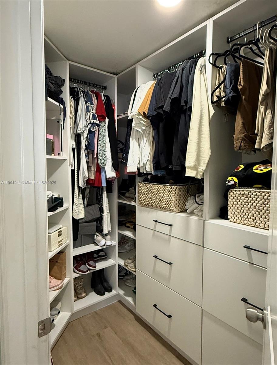 481 Northeast 194th Terrace, Unit 481 Miami, FL 33179 - Photo 13 of 23 a view of walk in closet with clothes and shoes