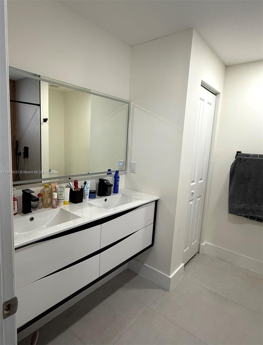 481 Northeast 194th Terrace, Unit 481 Miami, FL 33179 - Photo 14 of 23 a bathroom with a double vanity sink and mirror