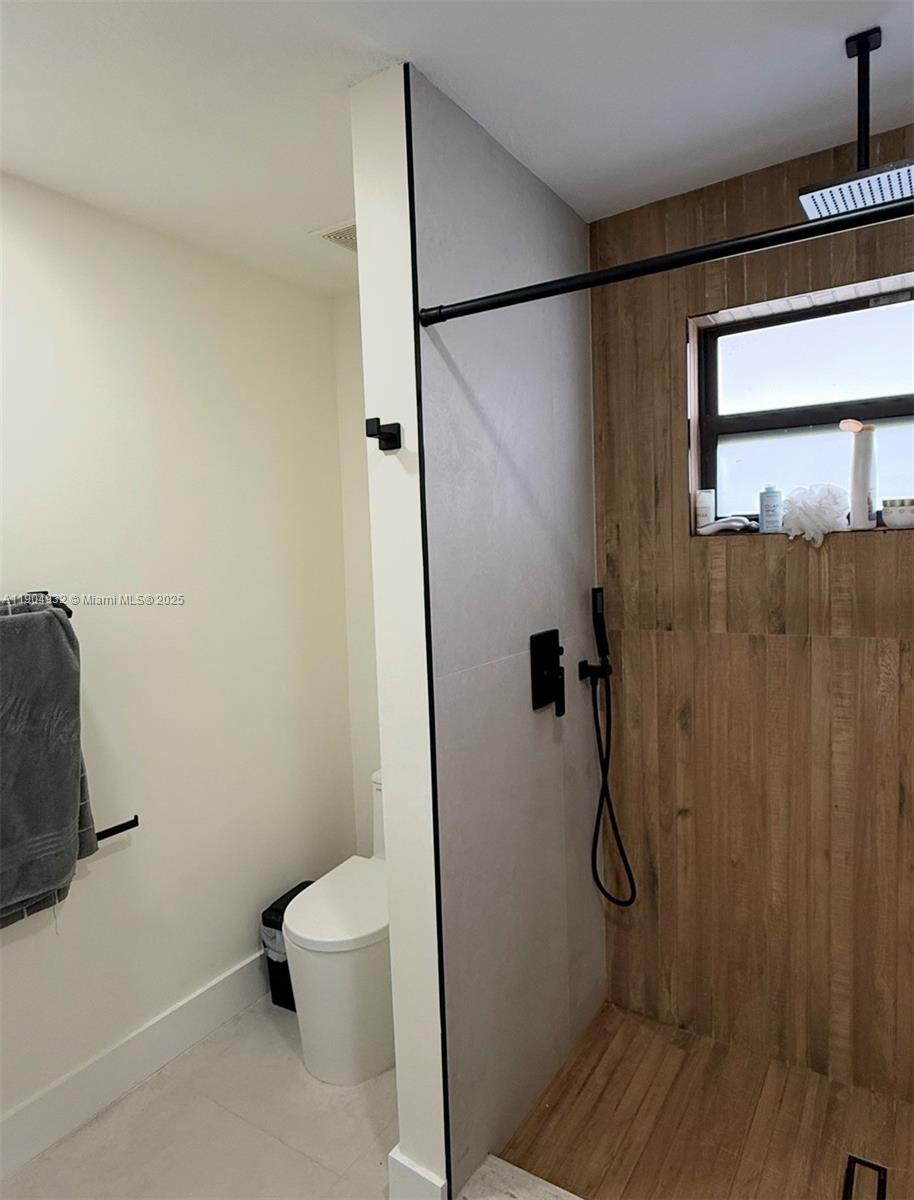 481 Northeast 194th Terrace, Unit 481 Miami, FL 33179 - Photo 15 of 23 a bathroom with a granite countertop shower and a toilet