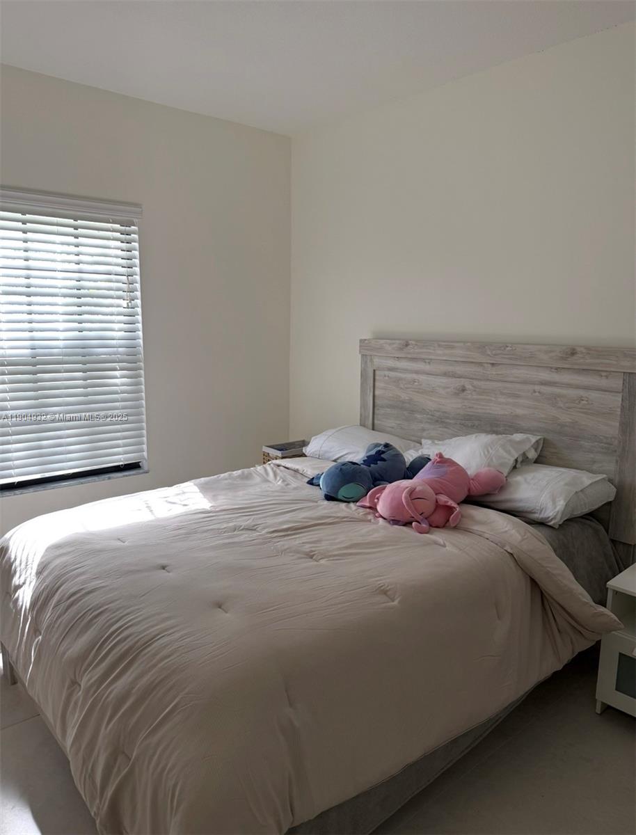 481 Northeast 194th Terrace, Unit 481 Miami, FL 33179 - Photo 16 of 23 a bedroom with a bed and window