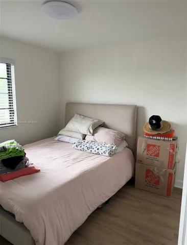 a bedroom with a bed and a potted plant