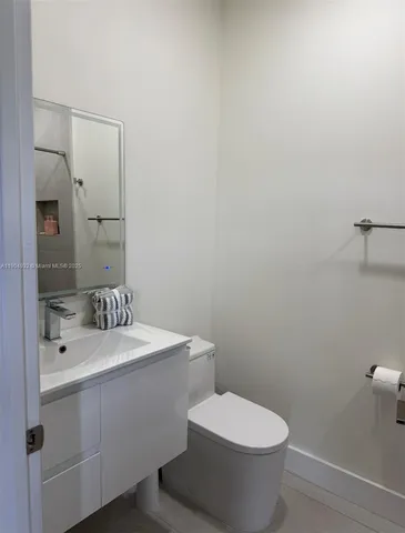 a bathroom with a sink a toilet and mirror