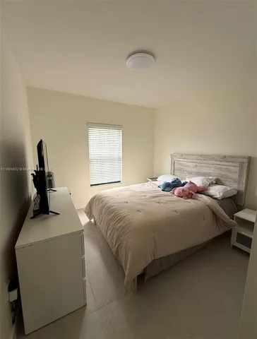 a bedroom with a bed and a dresser next to a window