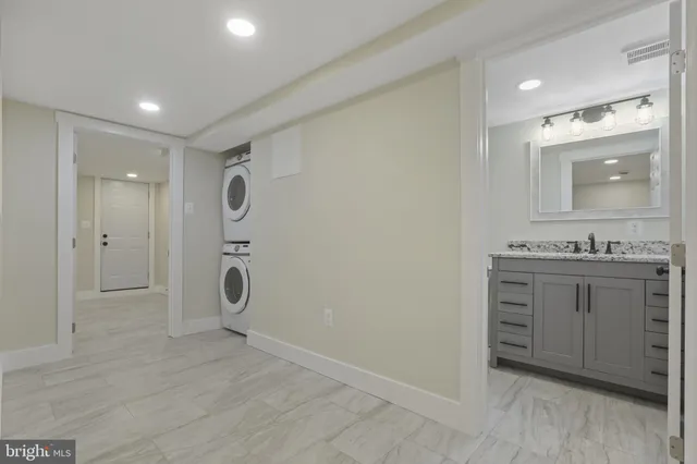 a bathroom with a granite countertop sink toilet a mirror a vanity and shower