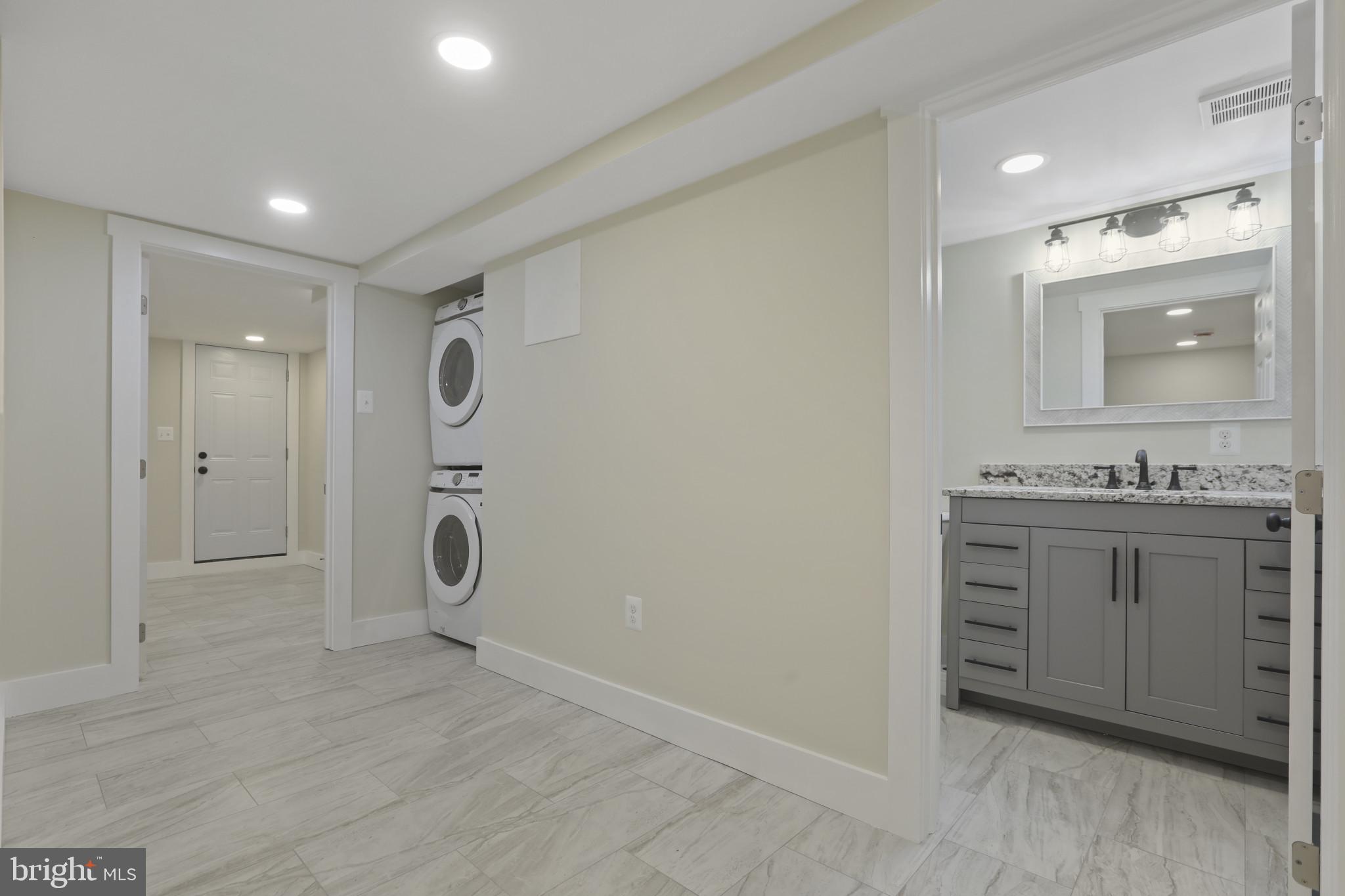 3828 10th Street Baltimore, MD 21225 - Photo 21 of 27 a bathroom with a granite countertop sink mirror and shower
