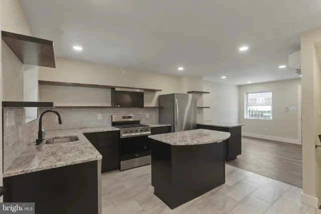a kitchen with stainless steel appliances granite countertop a sink counter space cabinets and a window