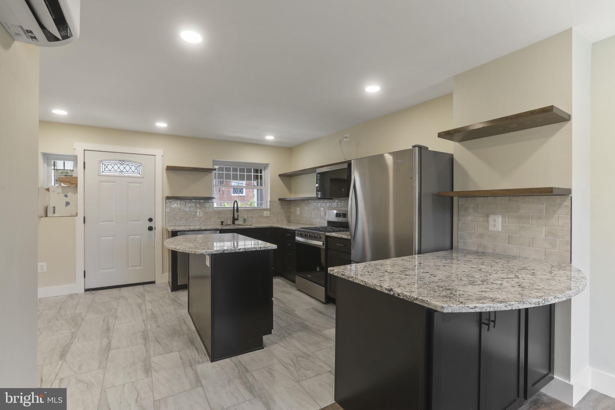 3828 10th Street Baltimore, MD 21225 - Photo 6 of 27 a kitchen with a table and refrigerator