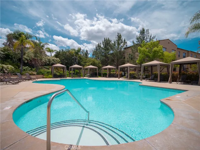 a view of yard with swimming pool and trees in the background