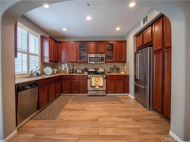 a kitchen with stainless steel appliances granite countertop a stove top oven a sink dishwasher a refrigerator and a refrigerator