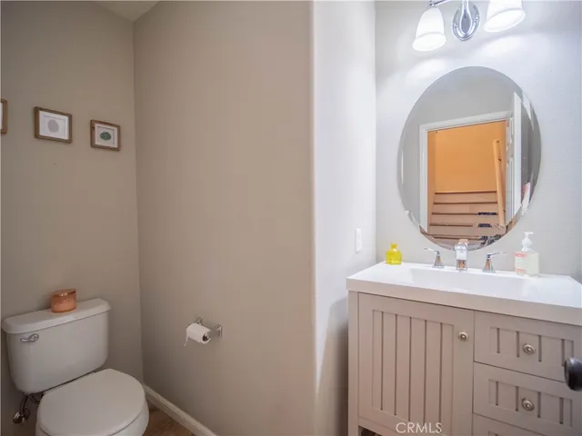 a bathroom with a toilet a sink a vanity and mirror