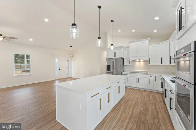 a view of a center island wooden floor and a ceiling fan