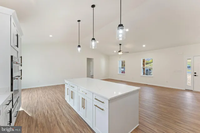 a kitchen with a sink wooden floor and white appliances