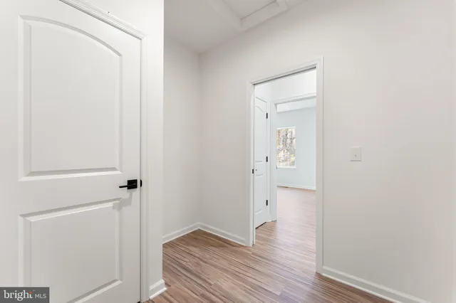 a view of empty room with wooden floor and ceiling fan