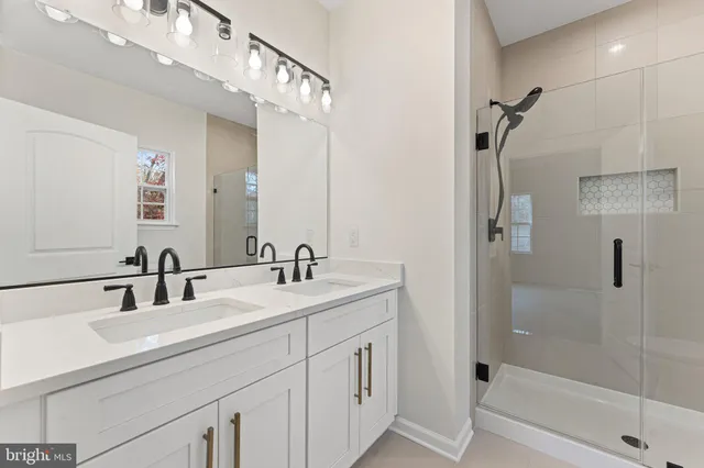 a bathroom with a double vanity sink mirror and shower