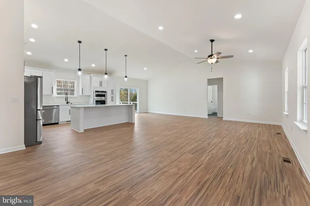 a view of empty room with wooden floor and window