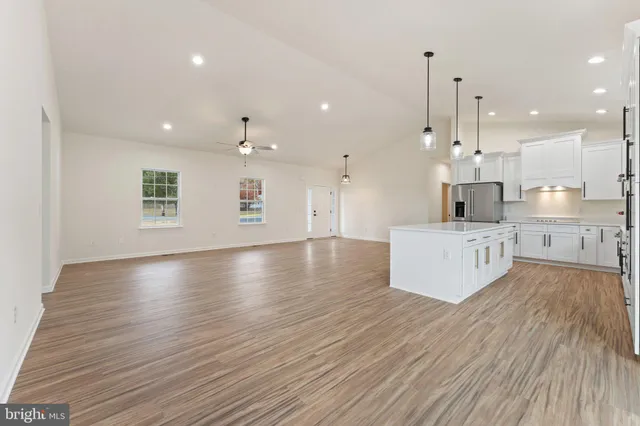 a kitchen with stainless steel appliances sink refrigerator and wooden floor