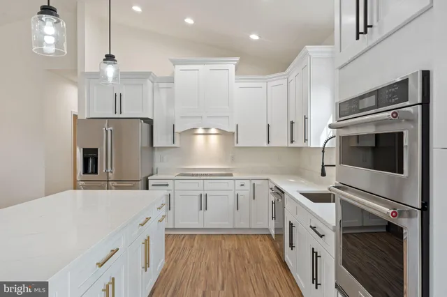 a large kitchen with stainless steel appliances lots of counter space sink refrigerator and cabinets
