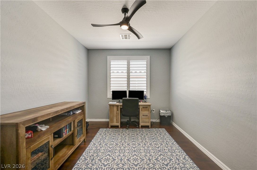 7049 Motley Road Las Vegas, NV 89178 - Photo 14 of 61 Rich hardwood flooring anchors this versatile space featuring a plantation-shuttered window.