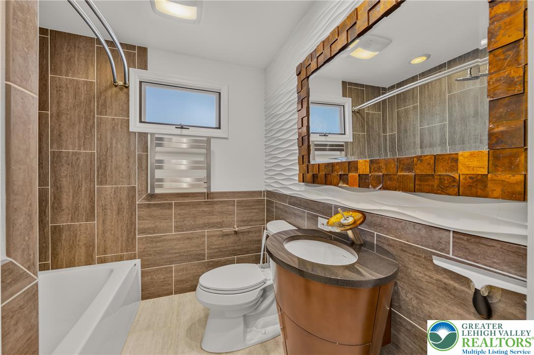 1814 Ruth Street Allentown, PA 18104 - Photo 30 of 54 Richly tiled walls pair with unique modern fixtures in this stylish bathroom design.