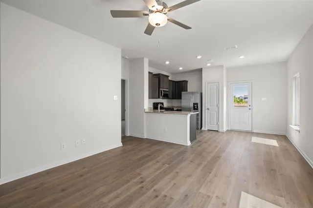 a view of a kitchen with a sink and dishwasher a refrigerator with wooden floor