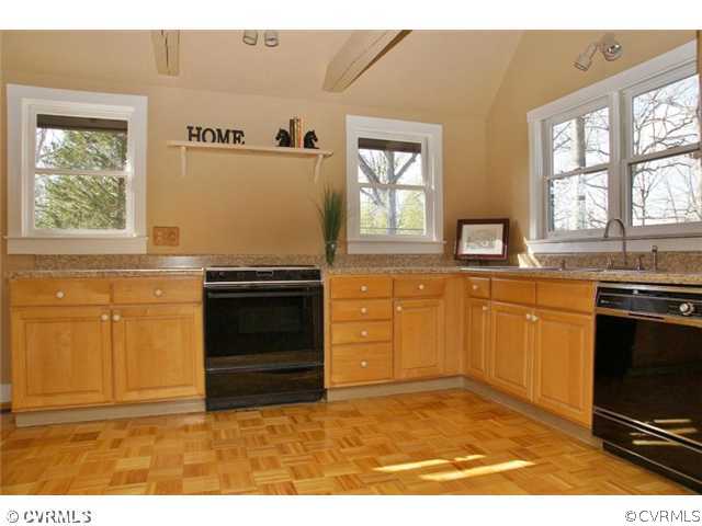 8976 Rustic Road Richmond, VA 23235 - Photo 5 of 12 a kitchen with granite countertop a stove a sink and a microwave