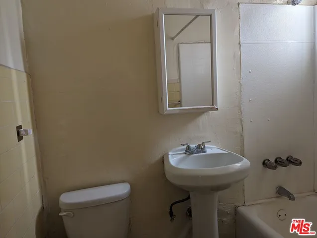 a bathroom with a sink toilet and a mirror