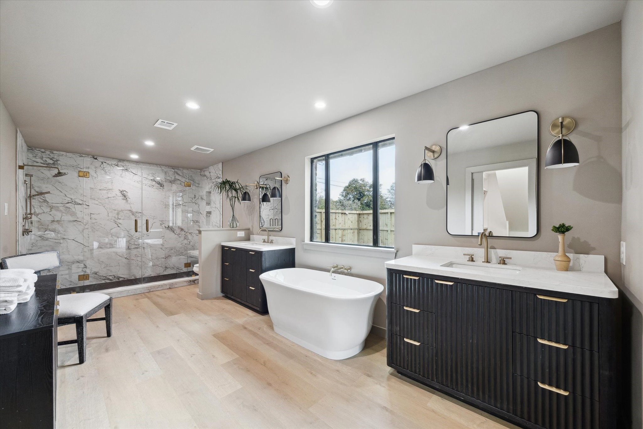 10402 Raritan Drive Houston, TX 77043 - Photo 15 of 27 a spacious bathroom with a double vanity sink a large mirror a bathtub and shower