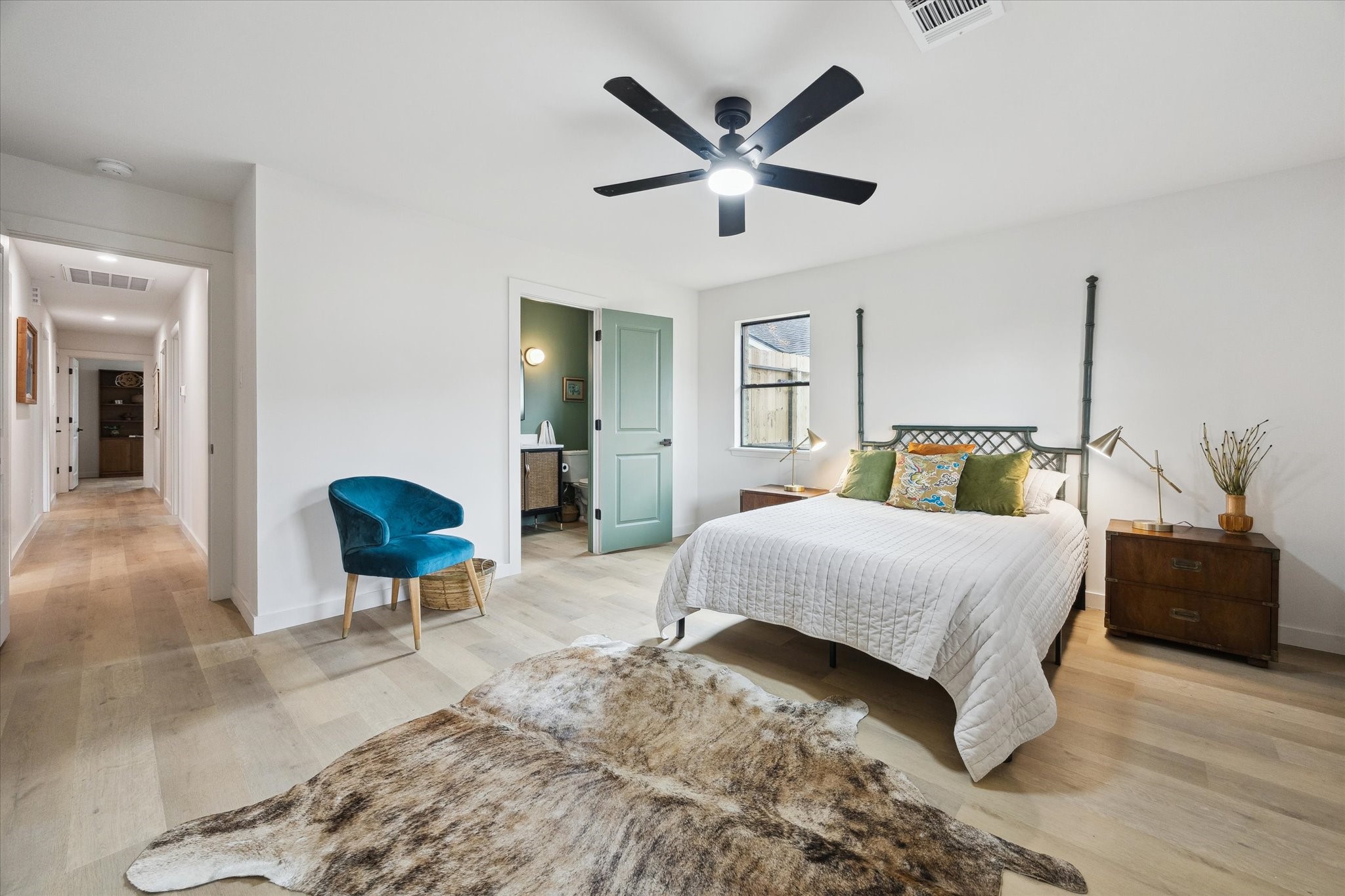 10402 Raritan Drive Houston, TX 77043 - Photo 22 of 27 a bedroom with a bed a table and painting on the wall