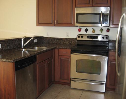 4262 Coventry Pointe Way Lake Worth, FL 33461 - Photo 2 of 12 a kitchen with granite countertop white cabinets and black appliances
