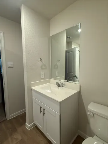 a bathroom with a sink a toilet a mirror and vanity