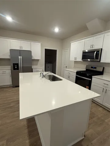 a kitchen with stainless steel appliances a refrigerator stove microwave and sink