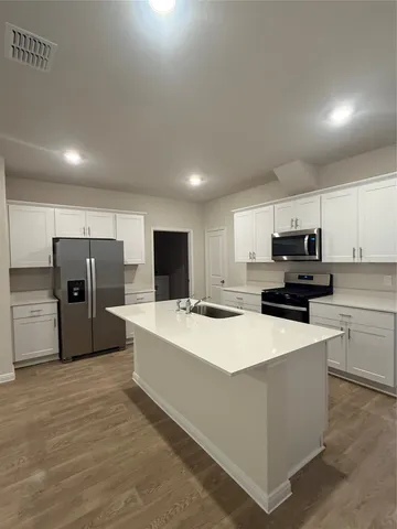 a kitchen with stainless steel appliances a refrigerator sink and microwave