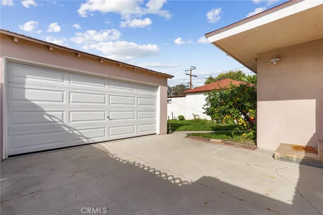 a view of a house with a yard and potted plants