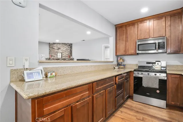 a kitchen with stainless steel appliances granite countertop a sink stove and microwave